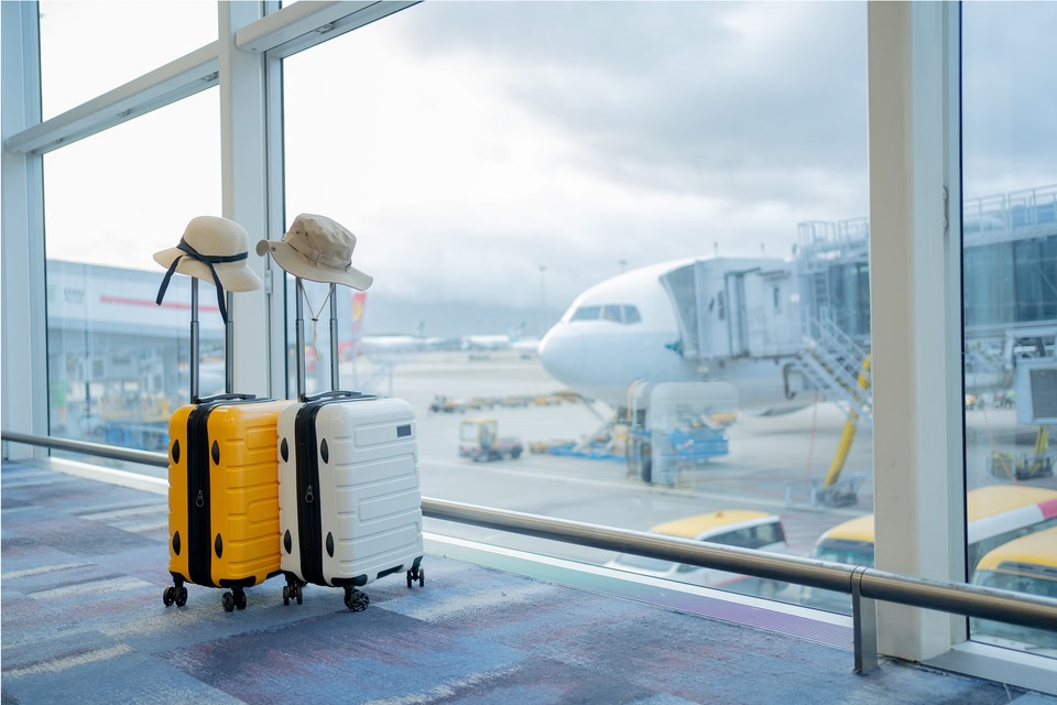 deux valises devant une fenêtre à l'aeroport