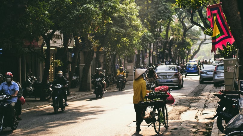 Hanoi road with fruit seller on bicycle