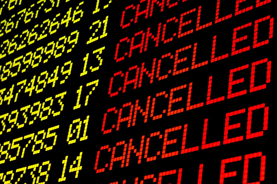 Flight status board at airport showing cancelled flights