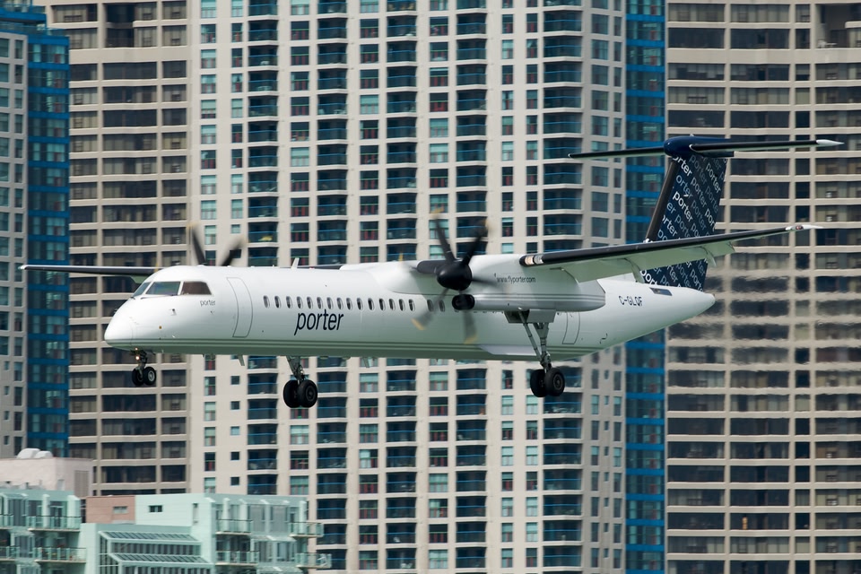 Porter plane landing in a city