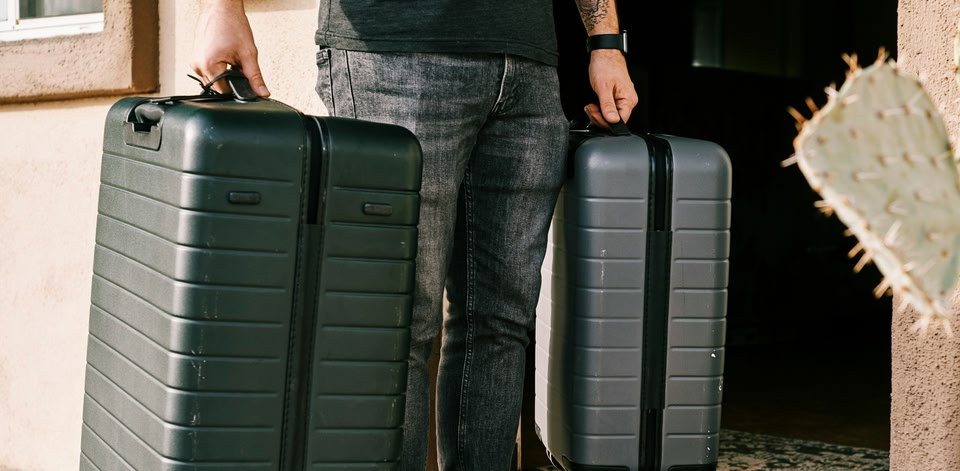 Reiziger met twee ruimbagagekoffers loopt naar de incheckbalie op een luchthaven