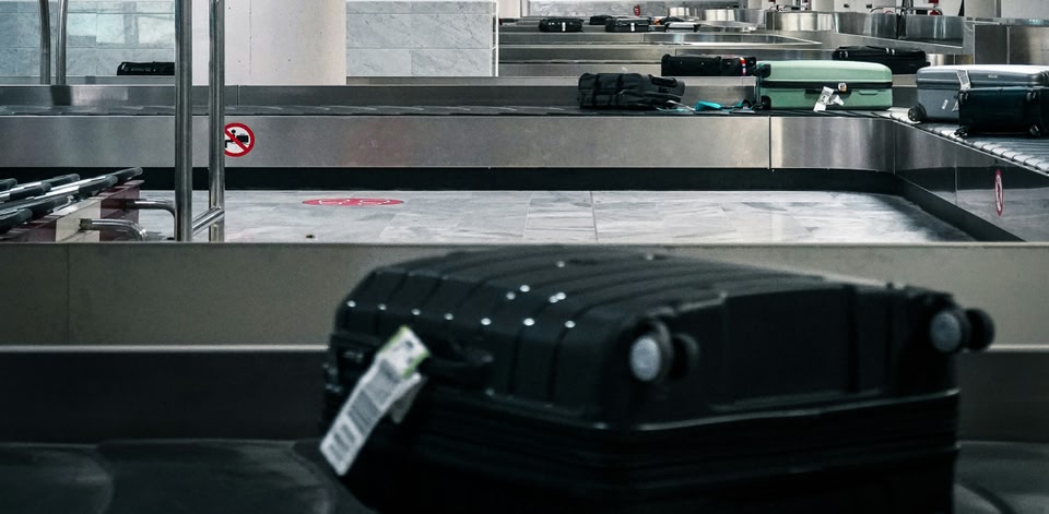 Koffers op een bagageband in de bagagehal van een luchthaven