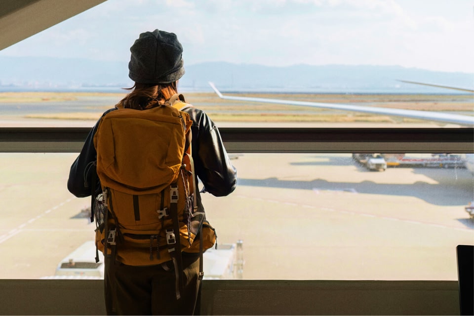 Reiziger met handbagage bij de gate op de luchthaven voor een vlucht