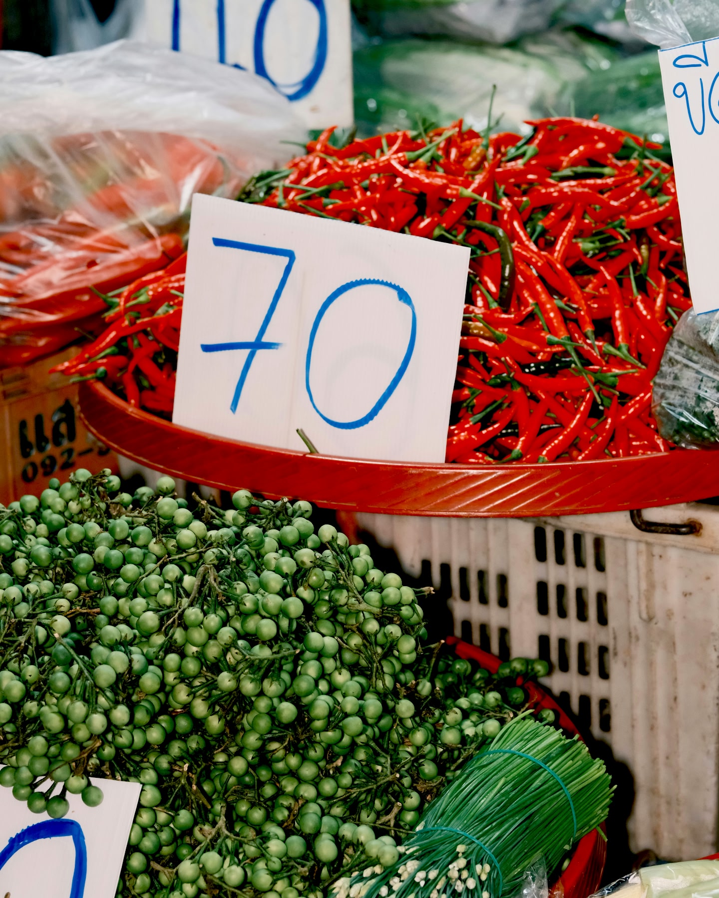 Fresh chillies and vegetables displayed at a market stall.