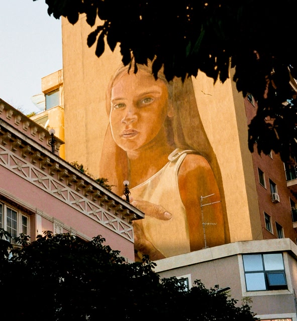 a Large Mural of a Woman on the Side of a Building in Tirana, Albania.