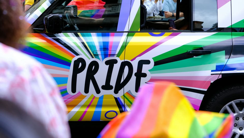 Auto in de kleuren van de LHBTQIA+-vlag met de tekst Pride erop