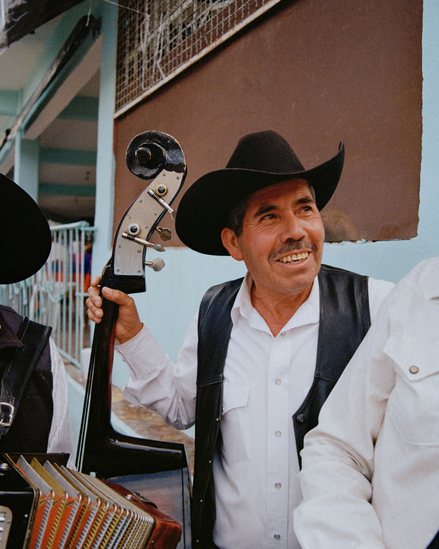 Musicien portant un chapeau de cowboy et tenant une contrebasse en plein air.