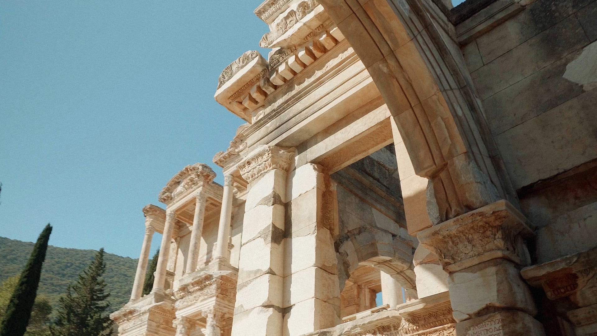 Ancien bâtiment en pierre aux colonnes et arches ornementées.