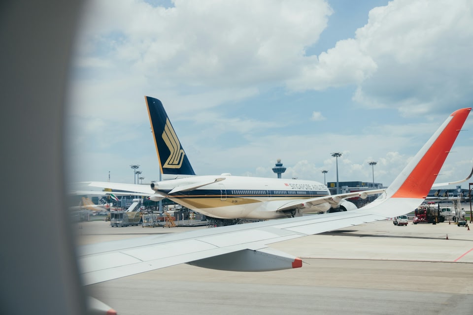 A photo from a plane window out onto the runway with a view of a Ryanair plane