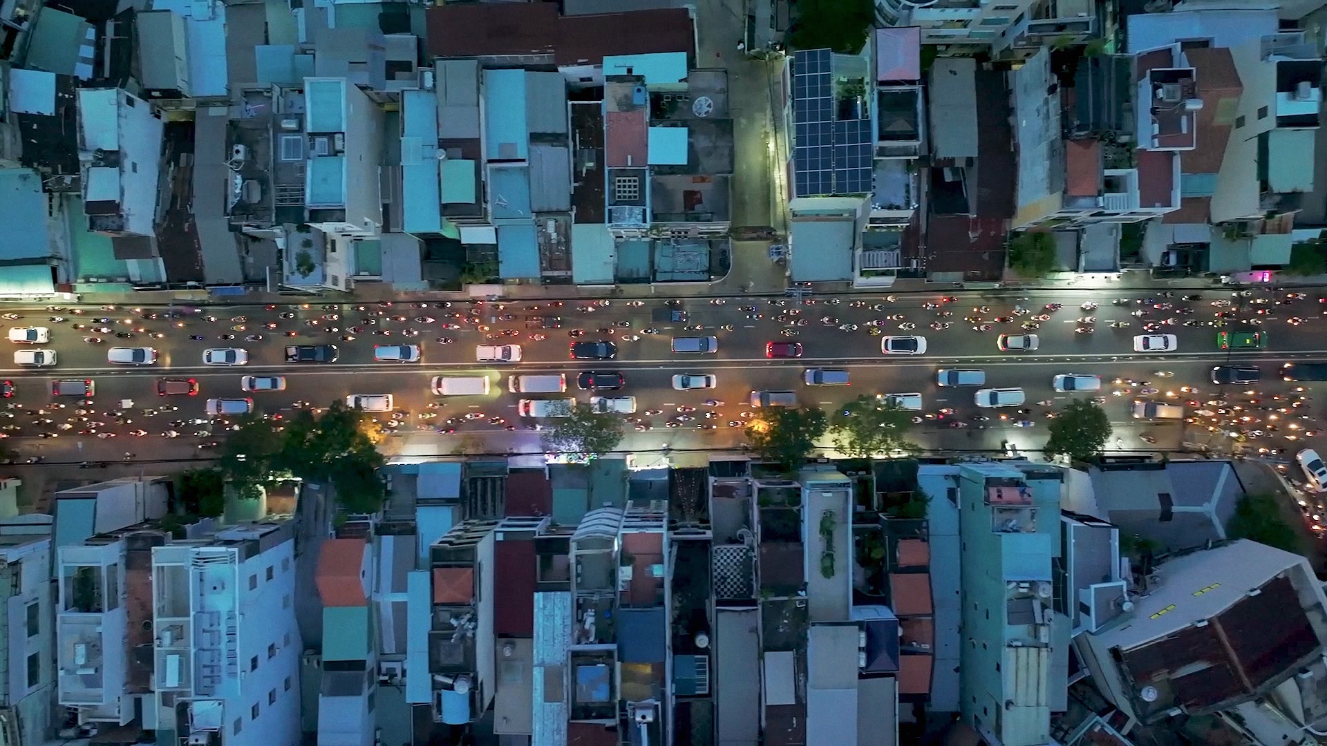 Vue aérienne d'une rue animée en ville au crépuscule.