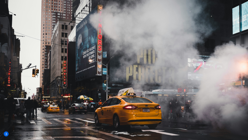 Taxi in New York tussen druk verkeer met stoom uit straatroosters