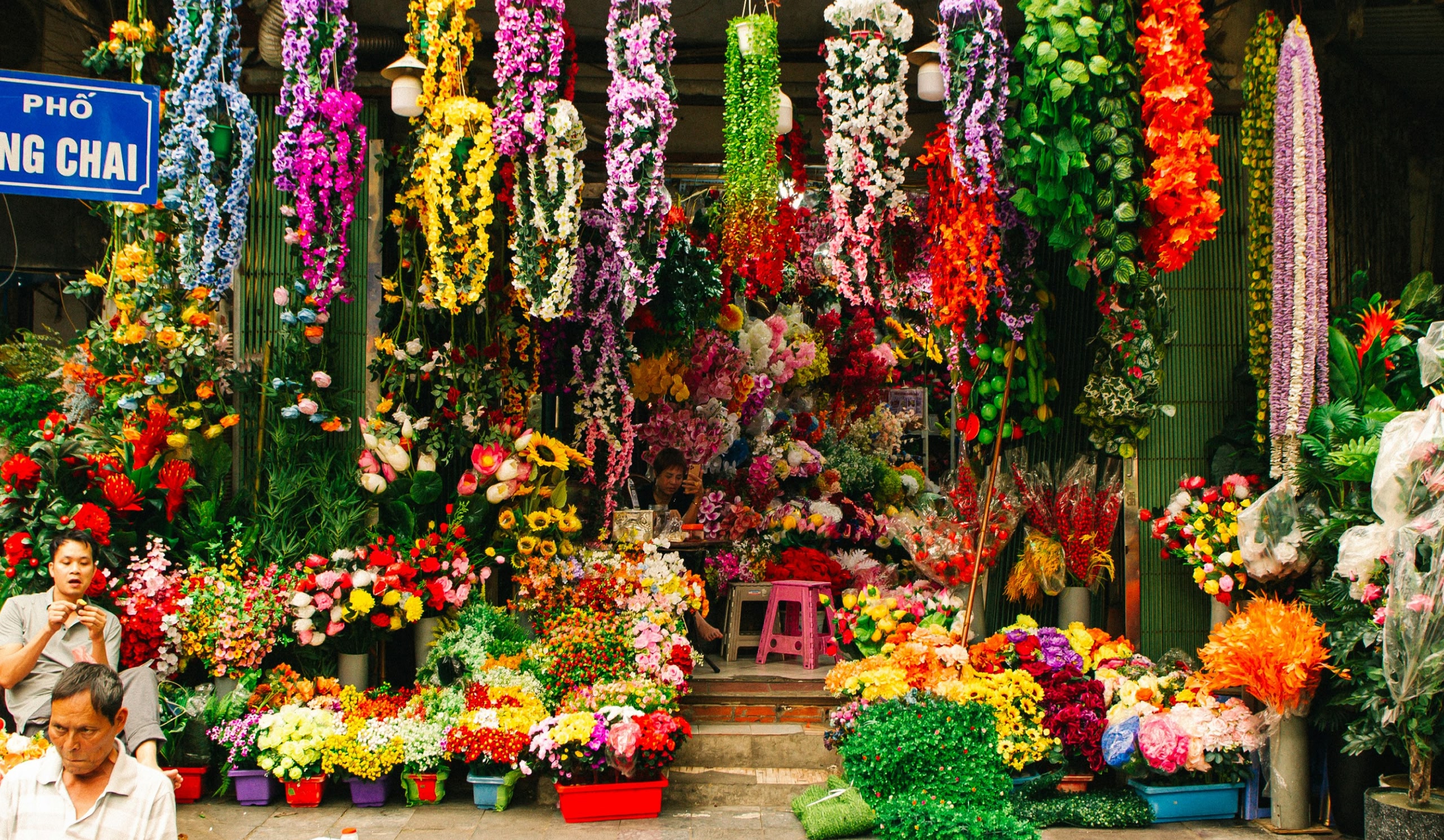 Colourful flower market with hanging floral displays and bouquets.