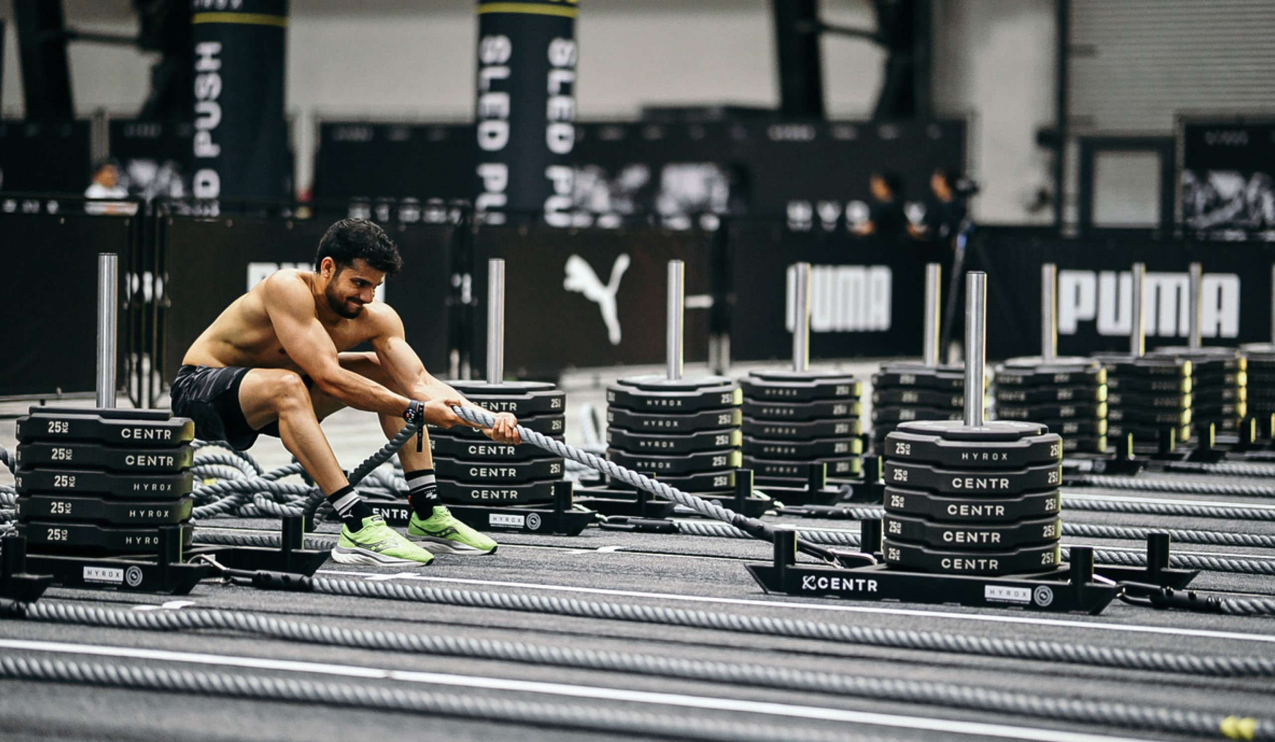Man exercising with ropes pulling a stack of weights across the floor