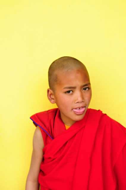 Тибетский мальчик показывает язык Тибетский мальчик в красном показывает язык в знак приветствия