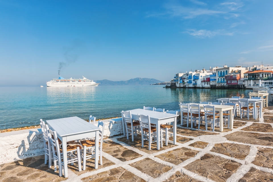 Ταβέρνα δίπλα στη θάλασσα με θέα ένα πλοίο που πλησιάζει στη Μύκονο
