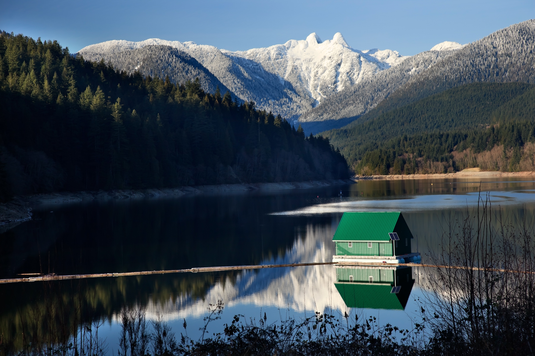 View of a green cabin in the mountains and lake in western Canada 