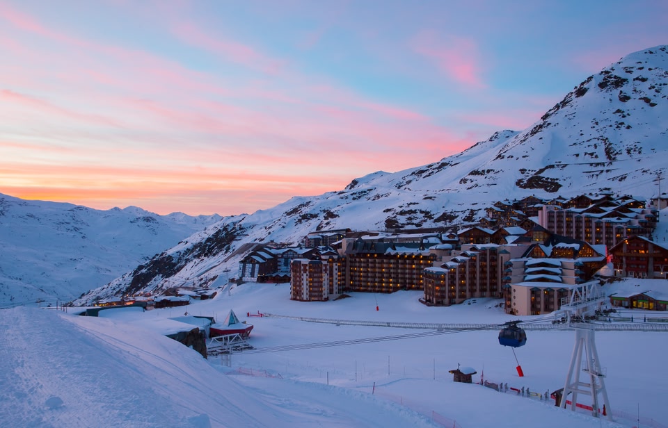 Ski chalets at sunset, with blushing pink skies.