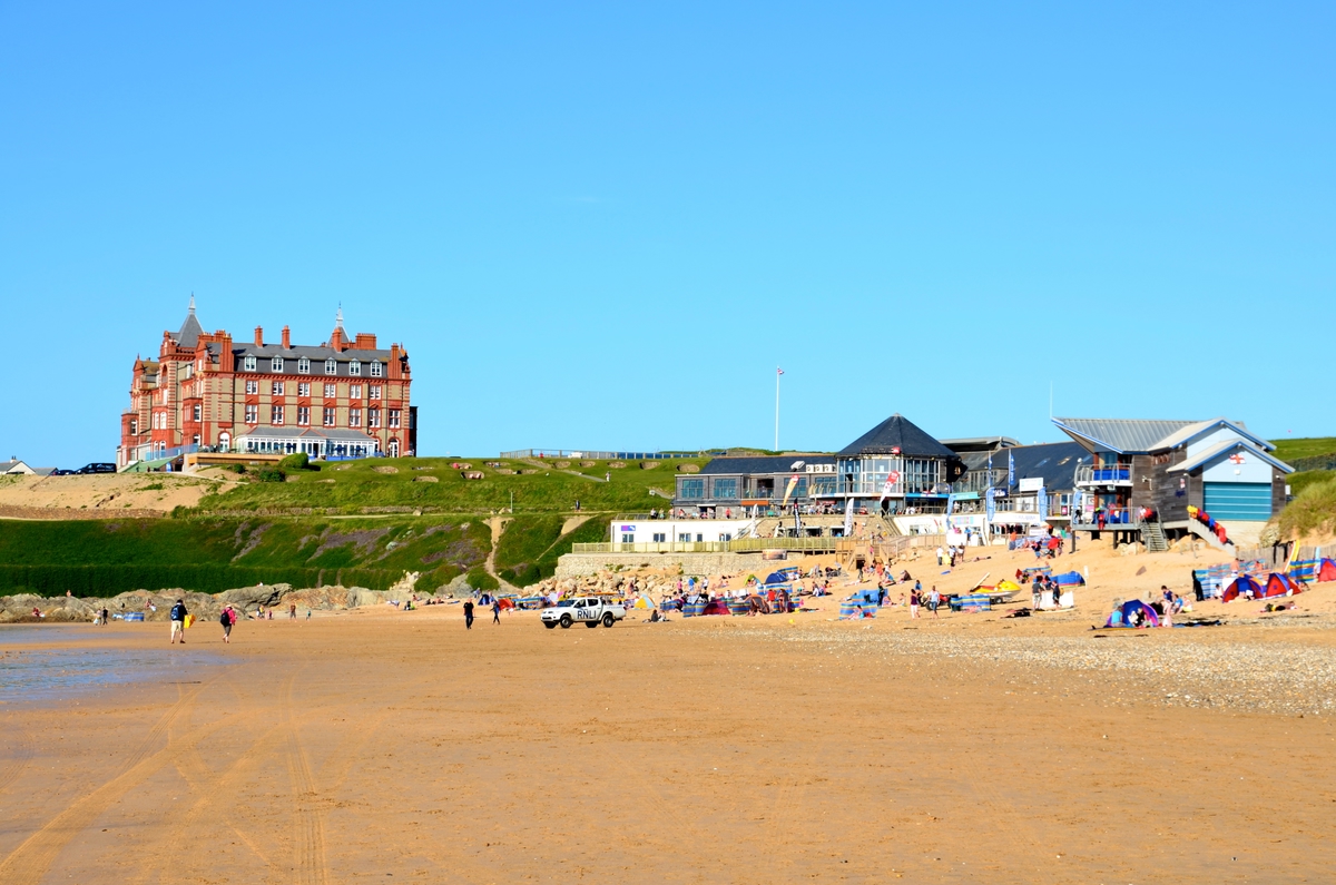 Families lying on a sandy beach in Newquay, England.