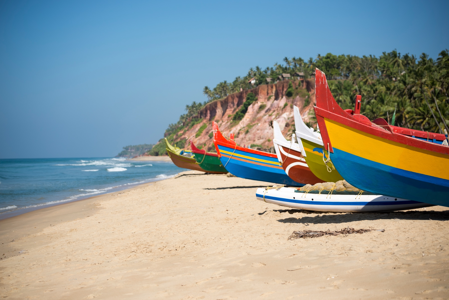 colourful wooden boats by the shore in kerala, india