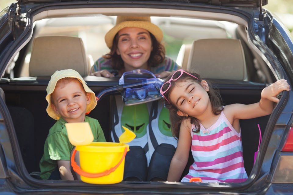 Mother and two kids at the back of a car - road trip with family