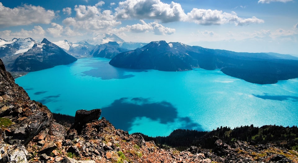 Turquoise lake surrounded by snow-capped mountains