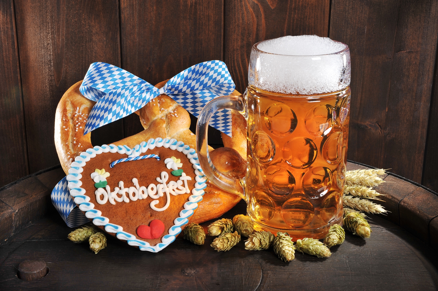 stein filled with beer, a decorated pretzel and Oktoberfest cookie