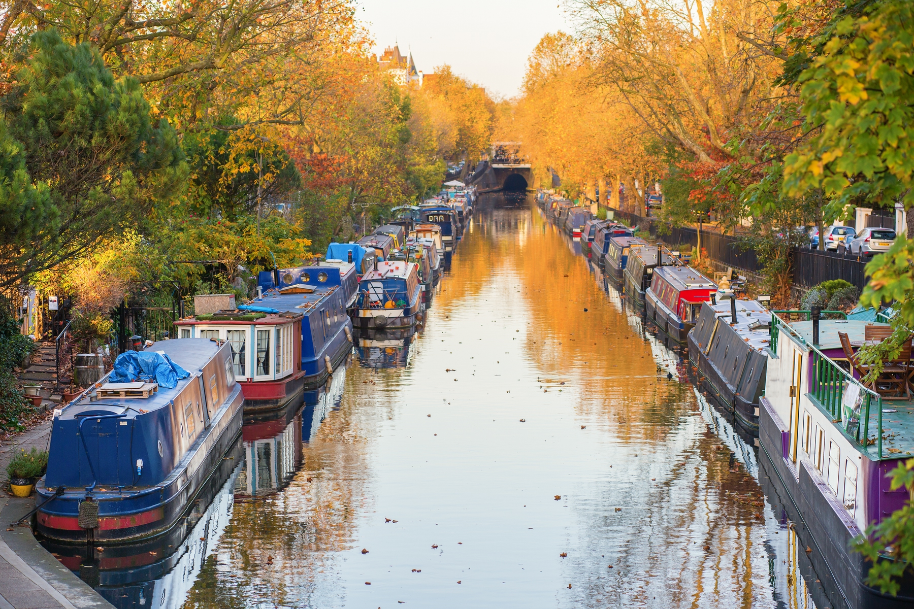 Little Venice in London. Colourful houseboats lining the Regent's Canal with autumn trees in the background.