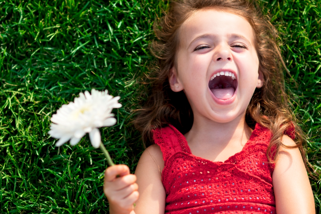Kid holding a flower, laying on the grass - St Stephen's Green Dublin