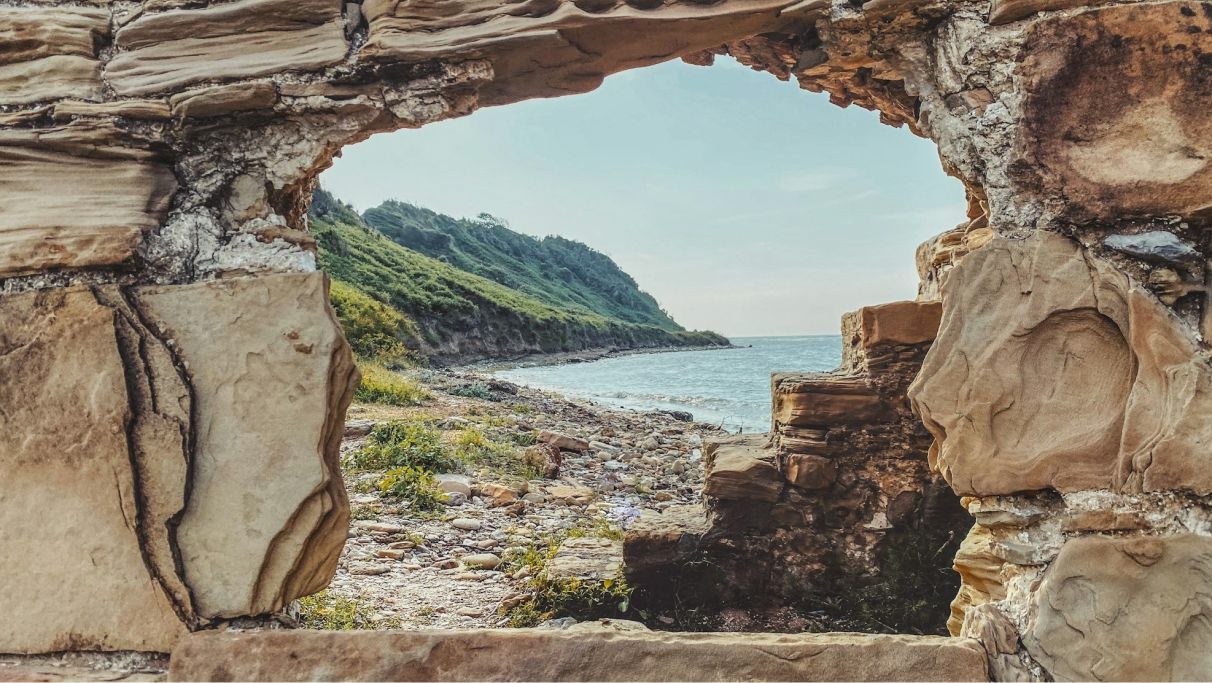 une photo du paysage marin de l'Albanie entouré de paysages verdoyants