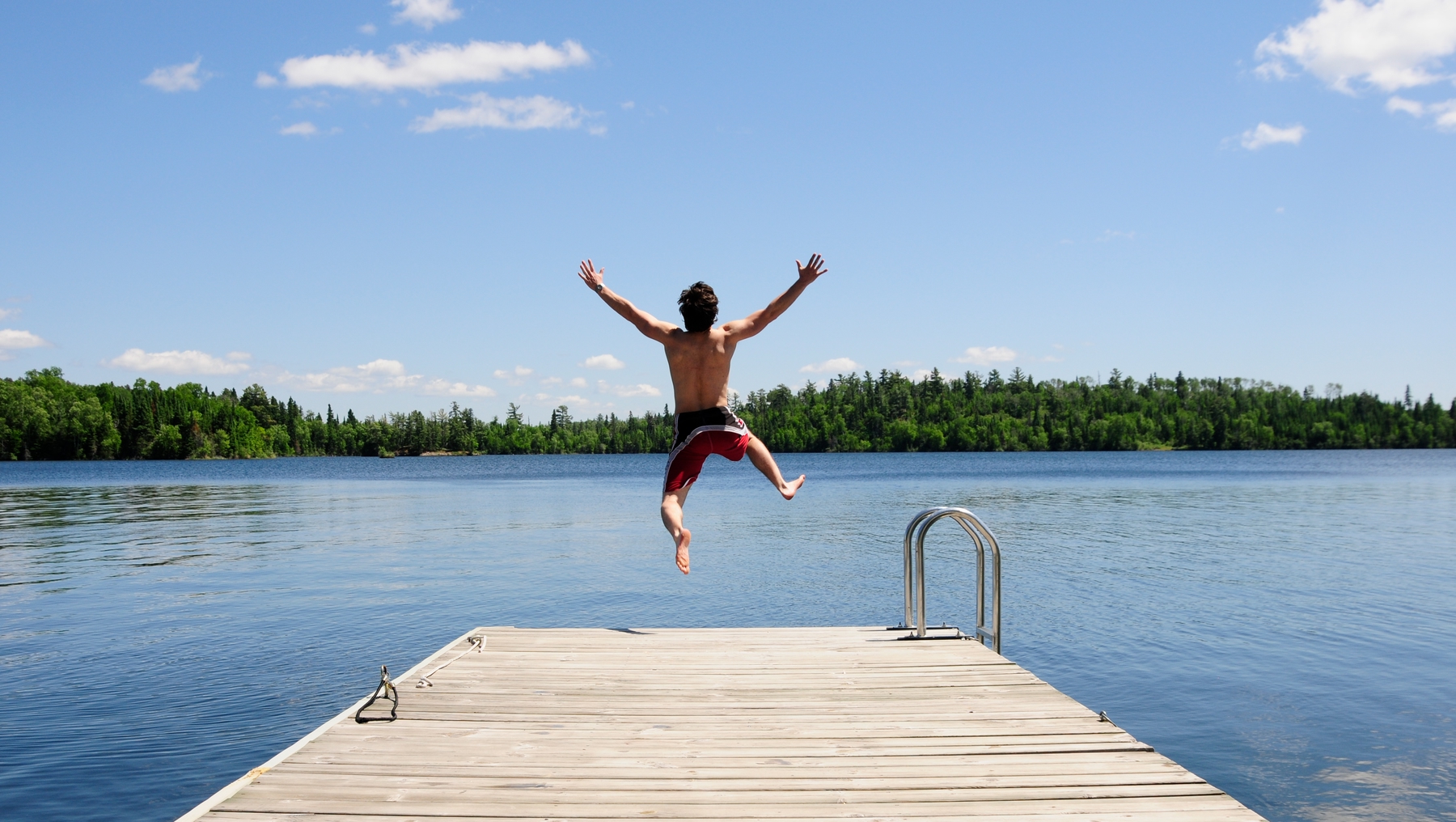 person jumping into a lake