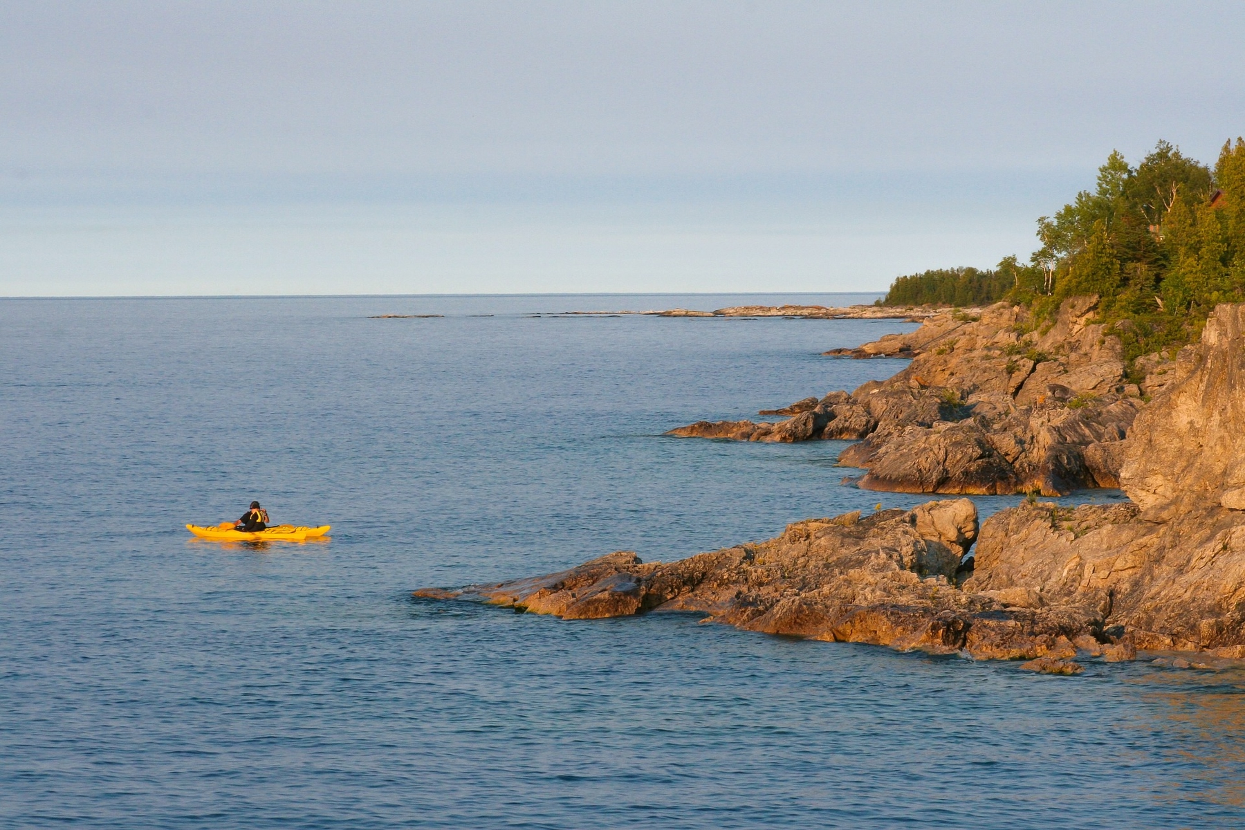 kayak in the water by the rocky shores of Georgian Bay, Ontario, around late afternoon