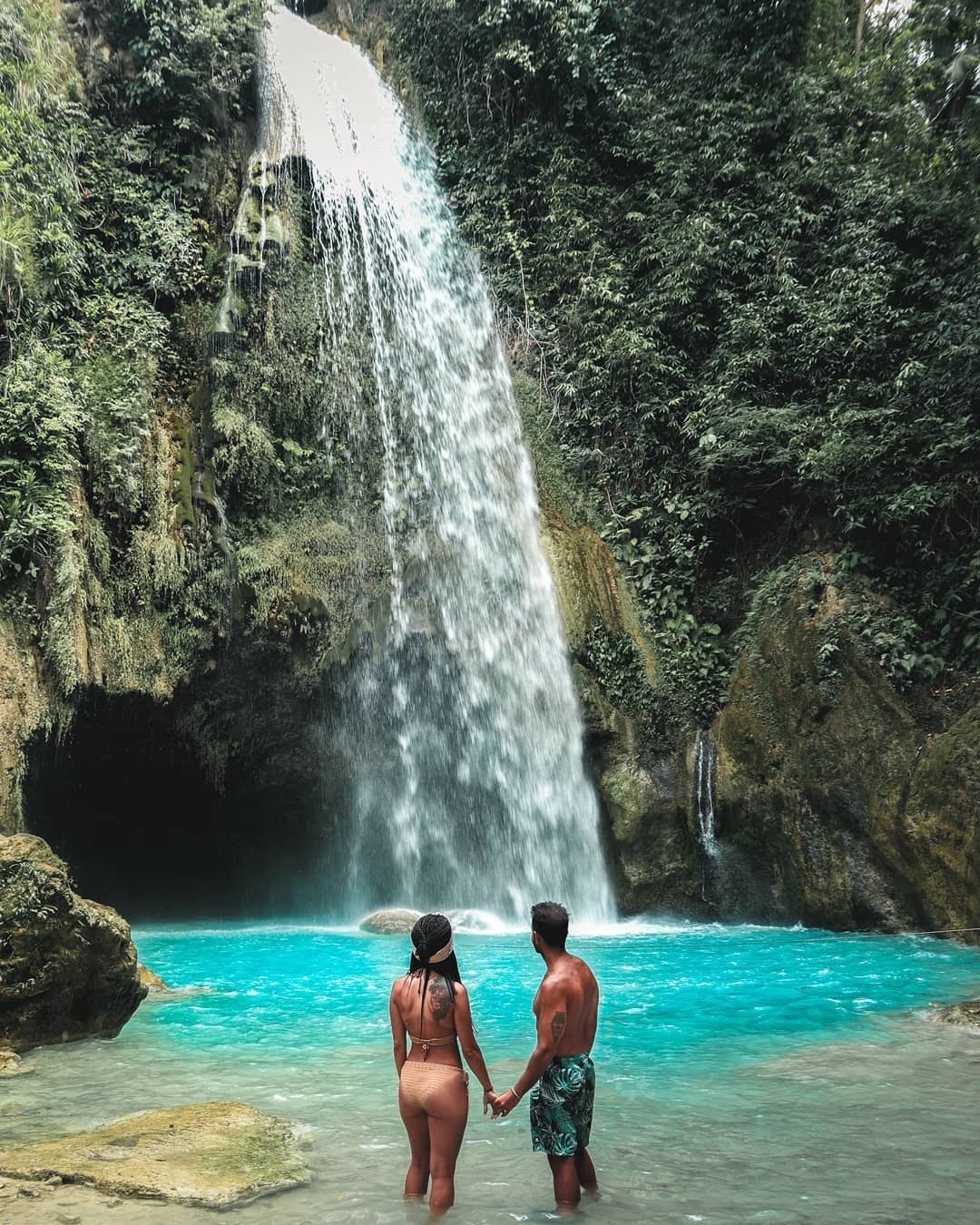 Where to go instead of Hawaii? A couple standing near the waterfall in Cebu, the Philippines