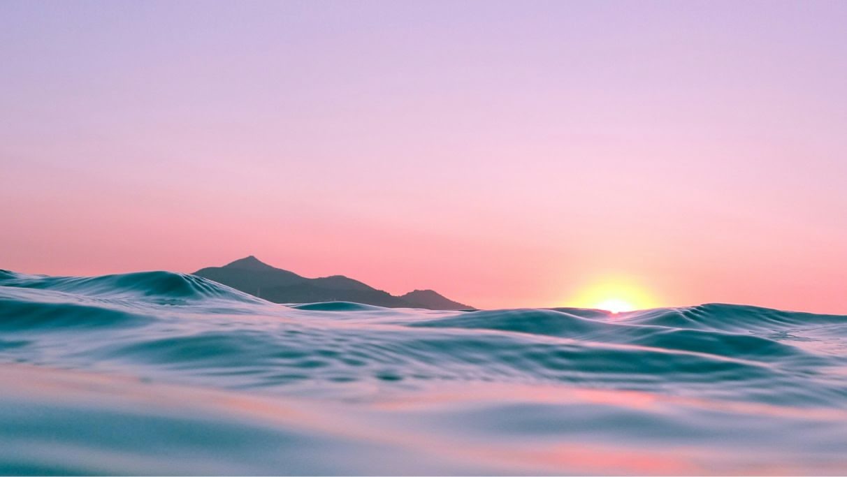 une image des vagues de la mer s'écrasant sur le rivage au coucher du soleil