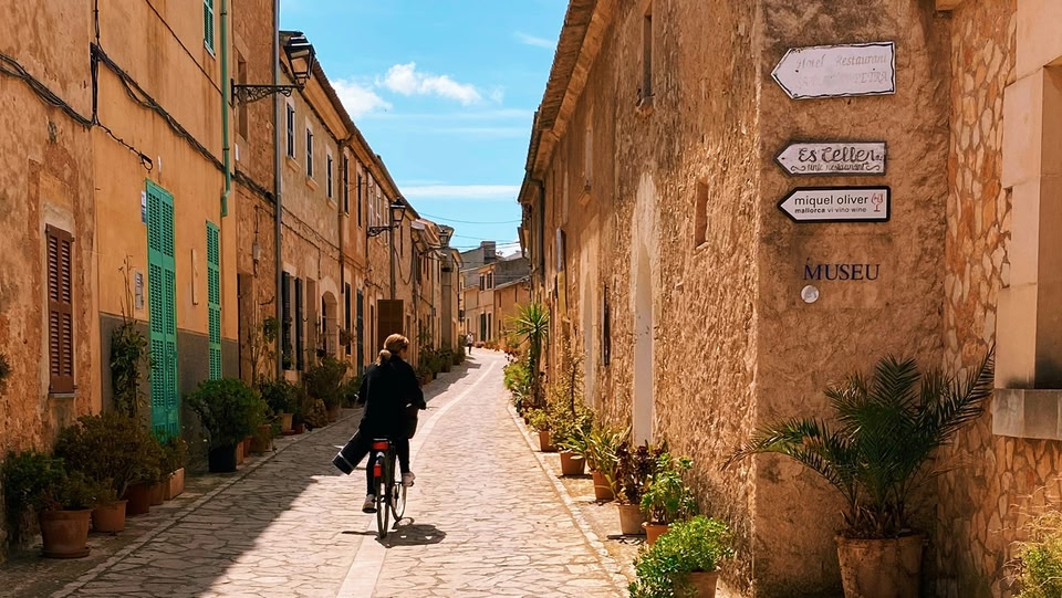 Strada di paese con una persona in bicicletta.