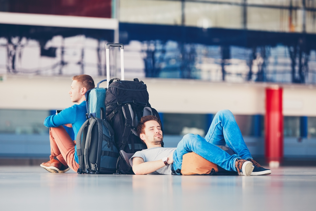 Dois amigos esperam no aeroporto seu voo cancelado ou atrasado.