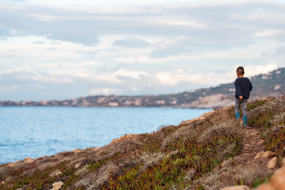 kid walking along the coastline