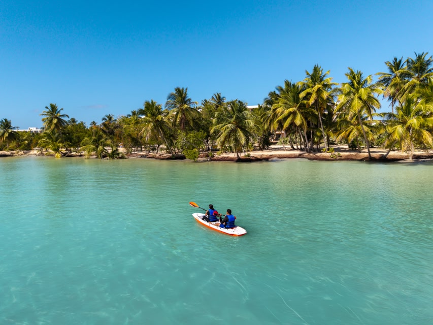 Duas pessoas em um caiaque na praia tranquila de Miches, República Dominicana - um dos destinos internacionais mais baratos para viajar em março