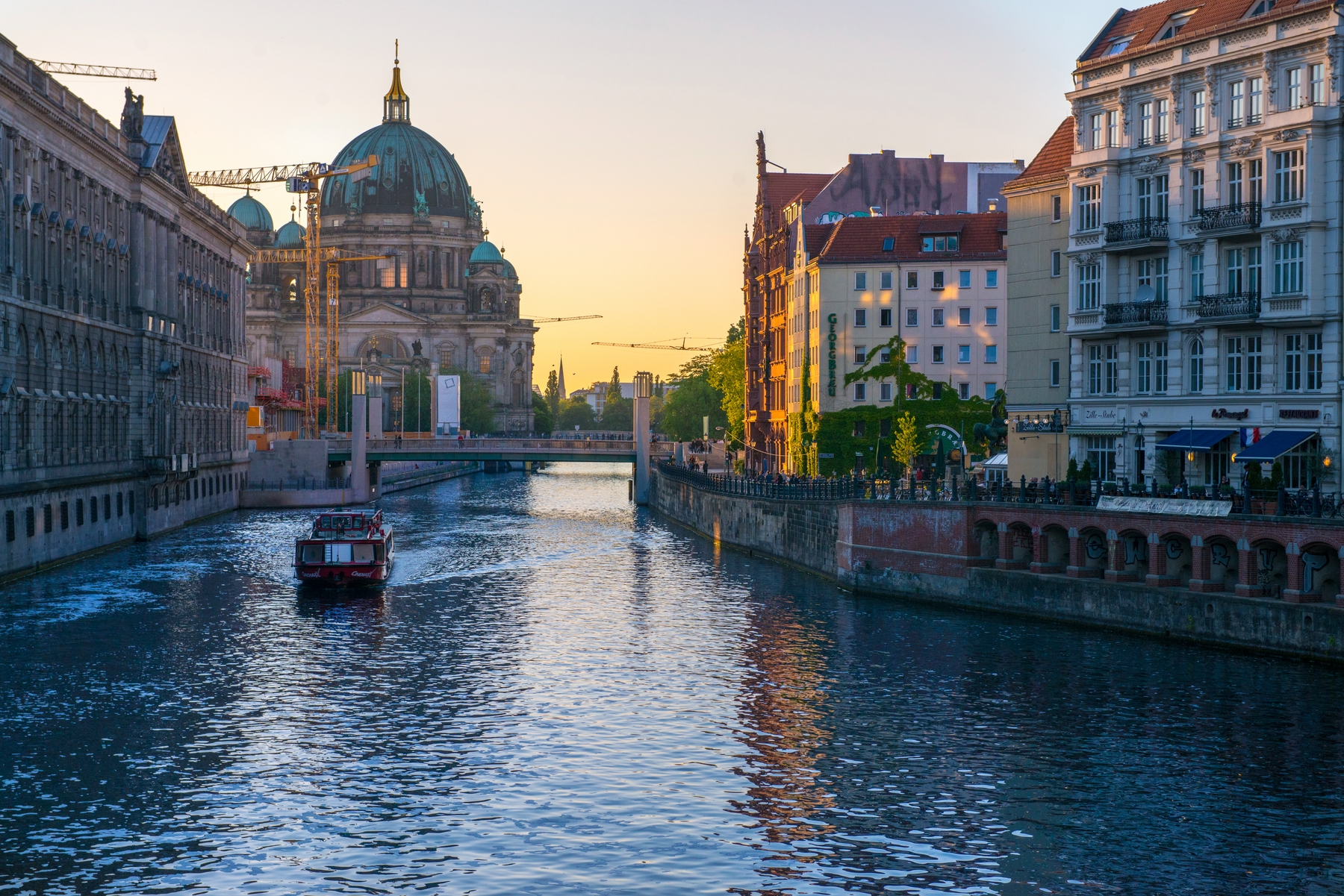 view of a boat along the canal in Berlin with the Berlin Cathedral in the background