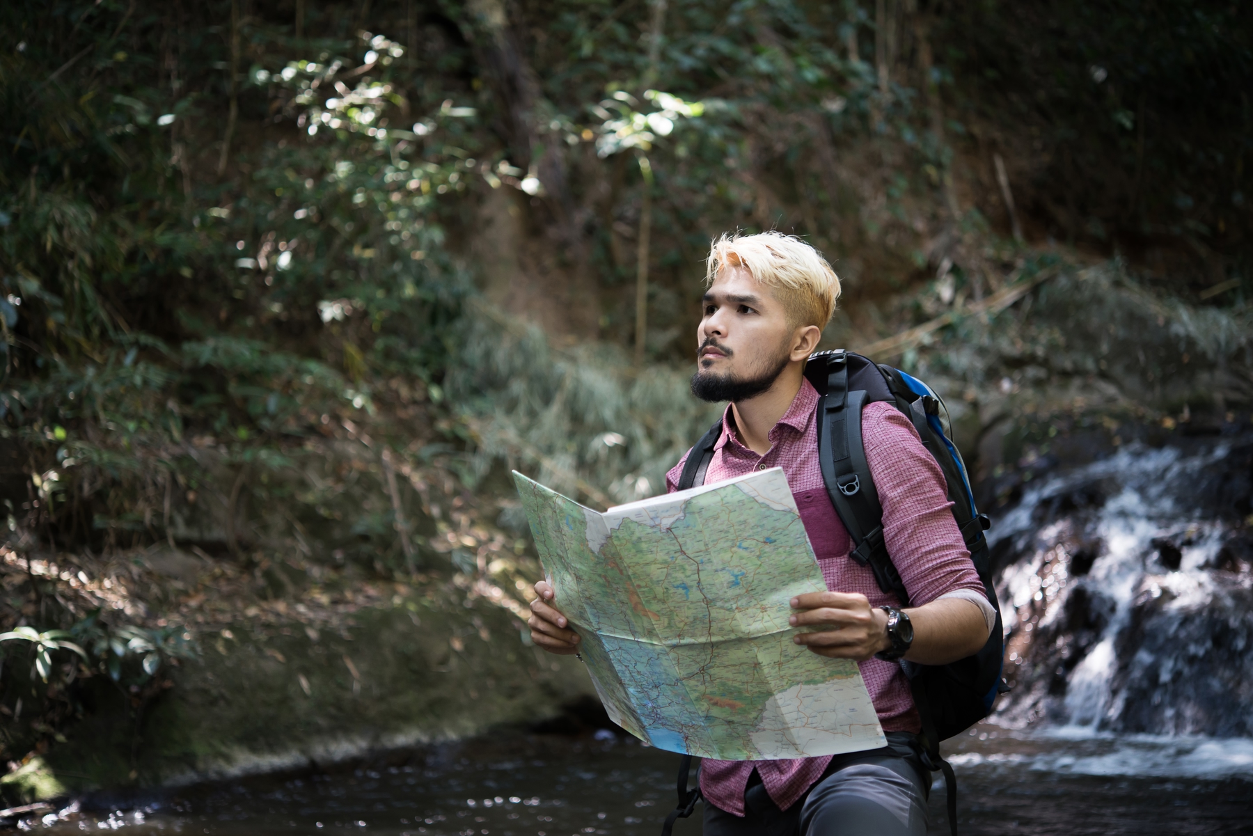 Man looking out to explore secret places from a map in the wilderness