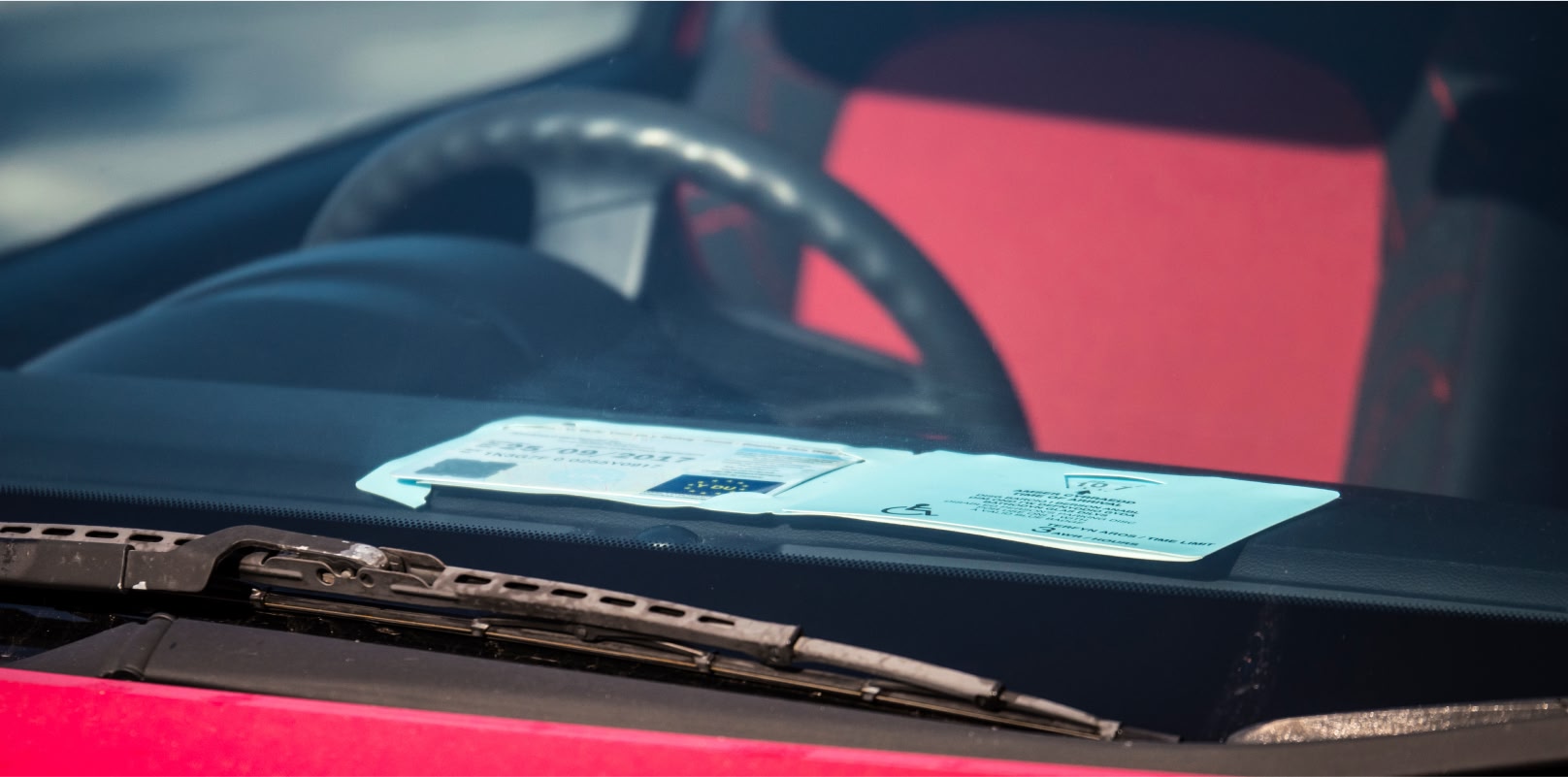 Image showing a blue badge displayed on a car dashboard.