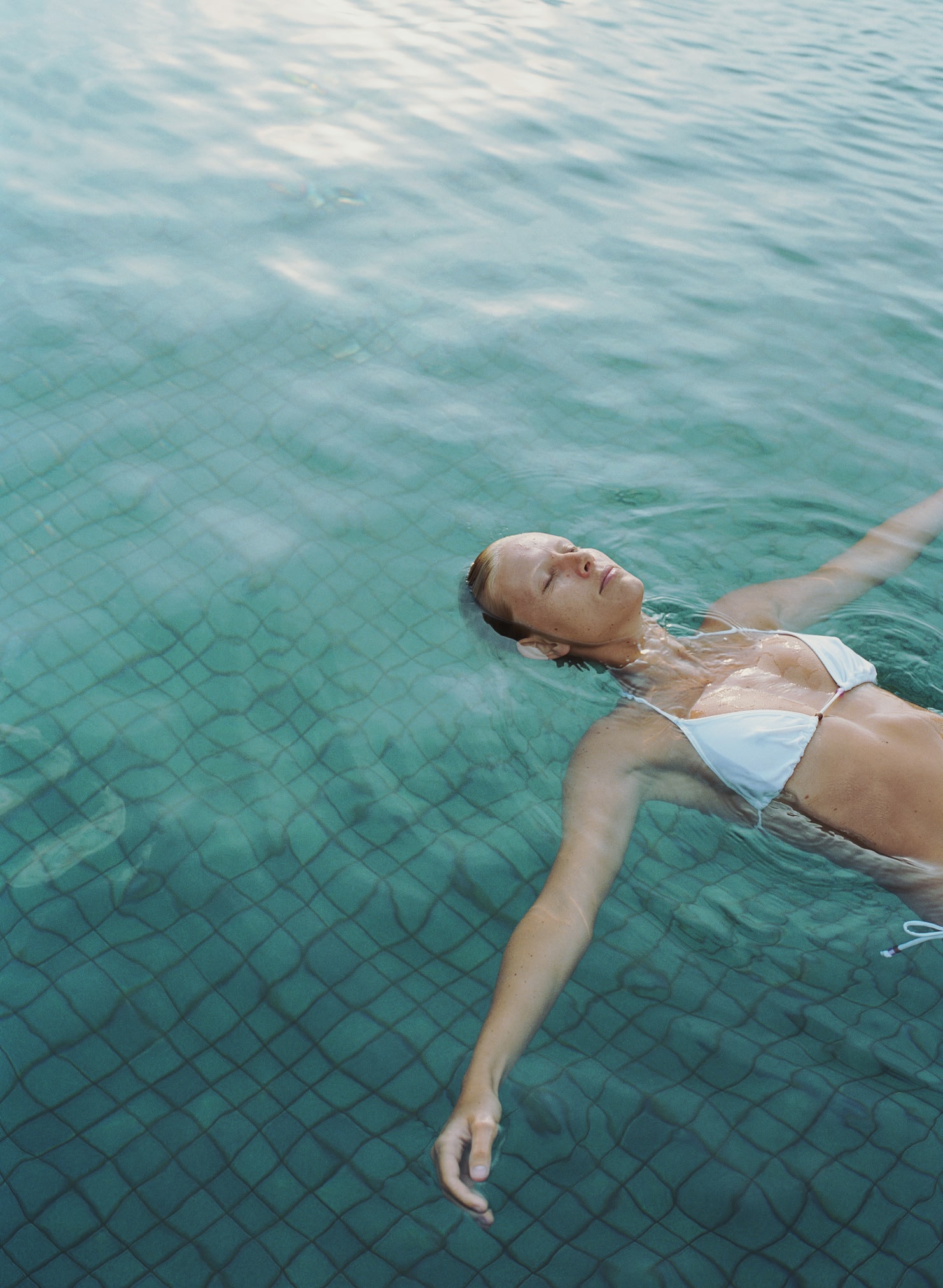 woman floating in a pool, relaxing.