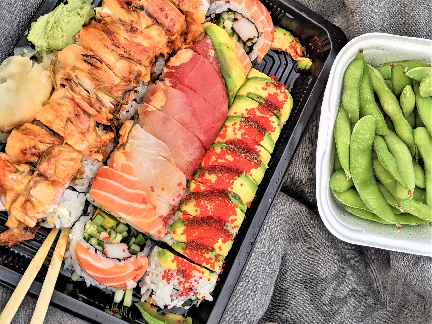 plate of sushi with edamame on the side