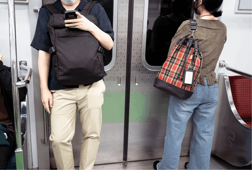 Two passengers inside a metro train near the doors—one man engrossed in his phone, and a woman facing the doors, prepared to disembark