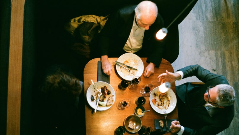 Una vista a volo d'uccello di 3 persone che cenano in un ristorante