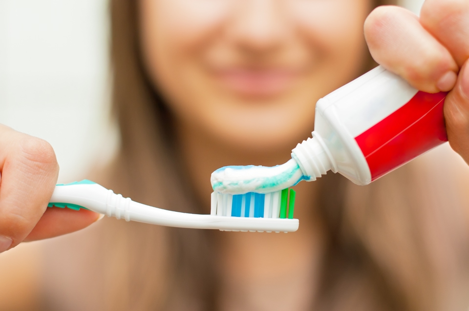 Squeezing toothpaste onto toothbrush