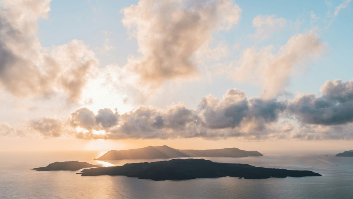 Immagine delle isole in Grecia durante il giorno con mare calmo e un cielo nuvoloso. 