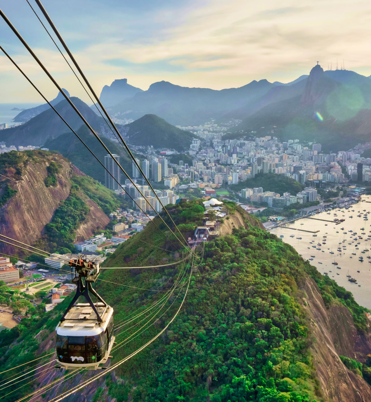 Un teleférico sobre Río de Janeiro, Brasil, con montañas y la ciudad en el fondo.