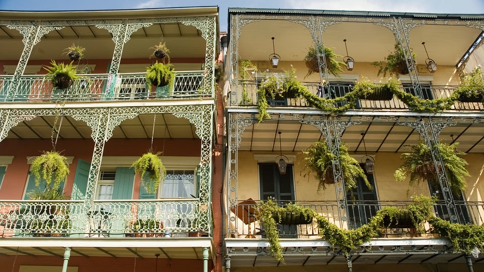 two adjacent buildings featuring ornate, wrought-iron balconies typical of New Orleans architecture
