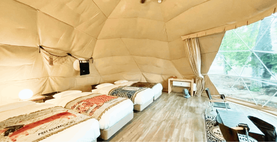 A look inside one of the day post general glamping pods. The interior has a large canvas window and 4 double beds