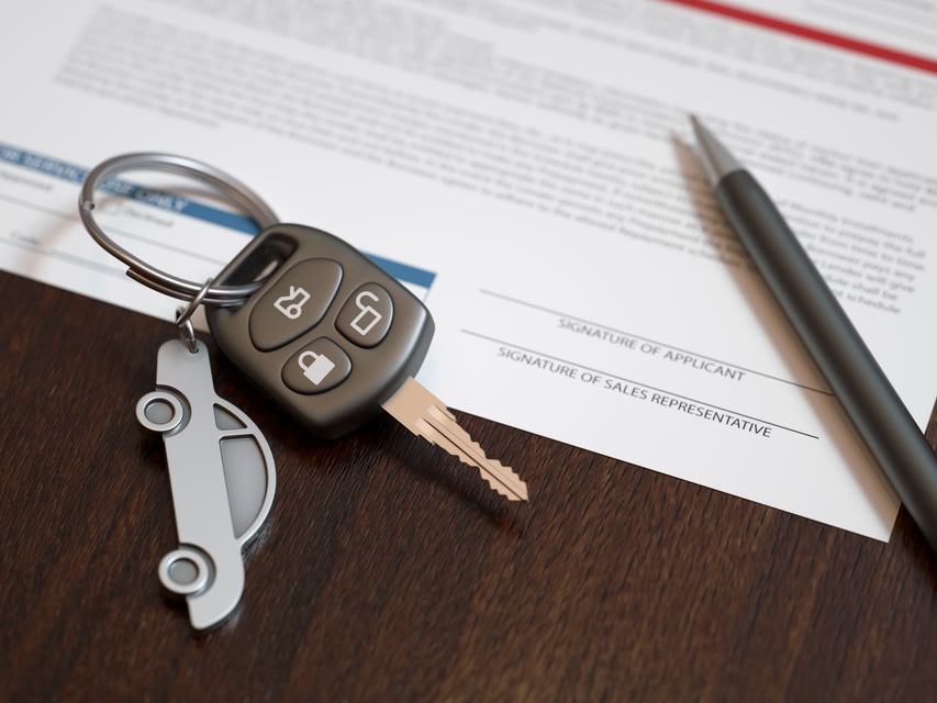 Car keys and pen laying on top of insurance documents